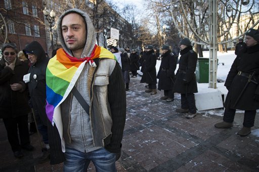 Credit: AP - In this Sunday, Jan. 19, 2014 file photo a Russian gay rights activist walks along a police line during a rally at a Moscow boulevard. When the Sochi Winter Olympics begin on Friday, Feb. 7, 2014, many will be watching to see whether Russia will enforce its law banning gay “propaganda” among minors if athletes, fans or activists wave rainbow flags or speak out in protest. The message so far has been confusing. (AP Photo/ Alexander Zemlianichenko, file)